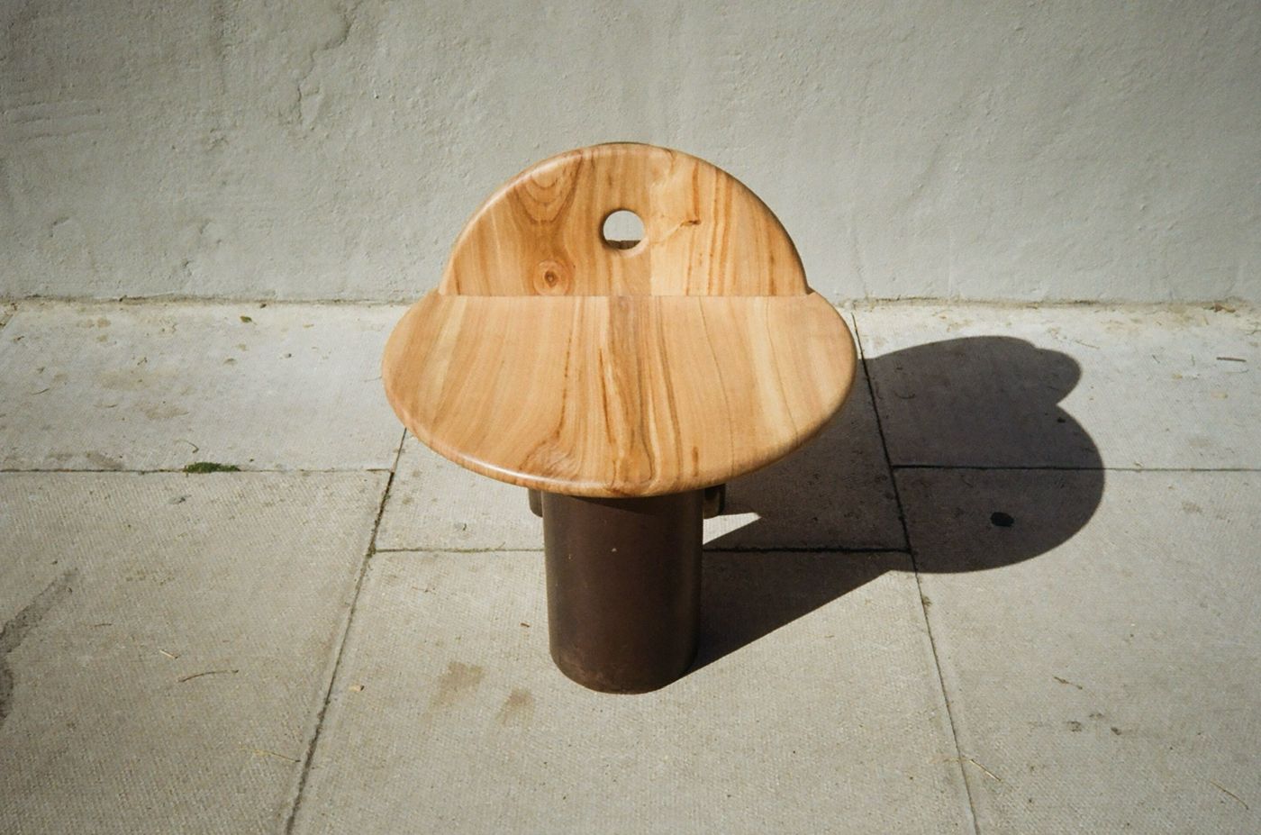 Raw mini stool from above, its round seat and backrest with a circular cut-out