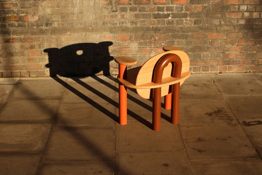 The TOT Chair from behind, shadow cast on brick