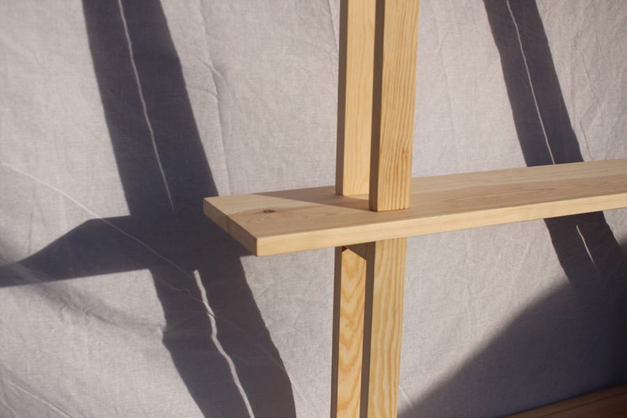 Close-up of a shelf meeting its legs, with shadows behind