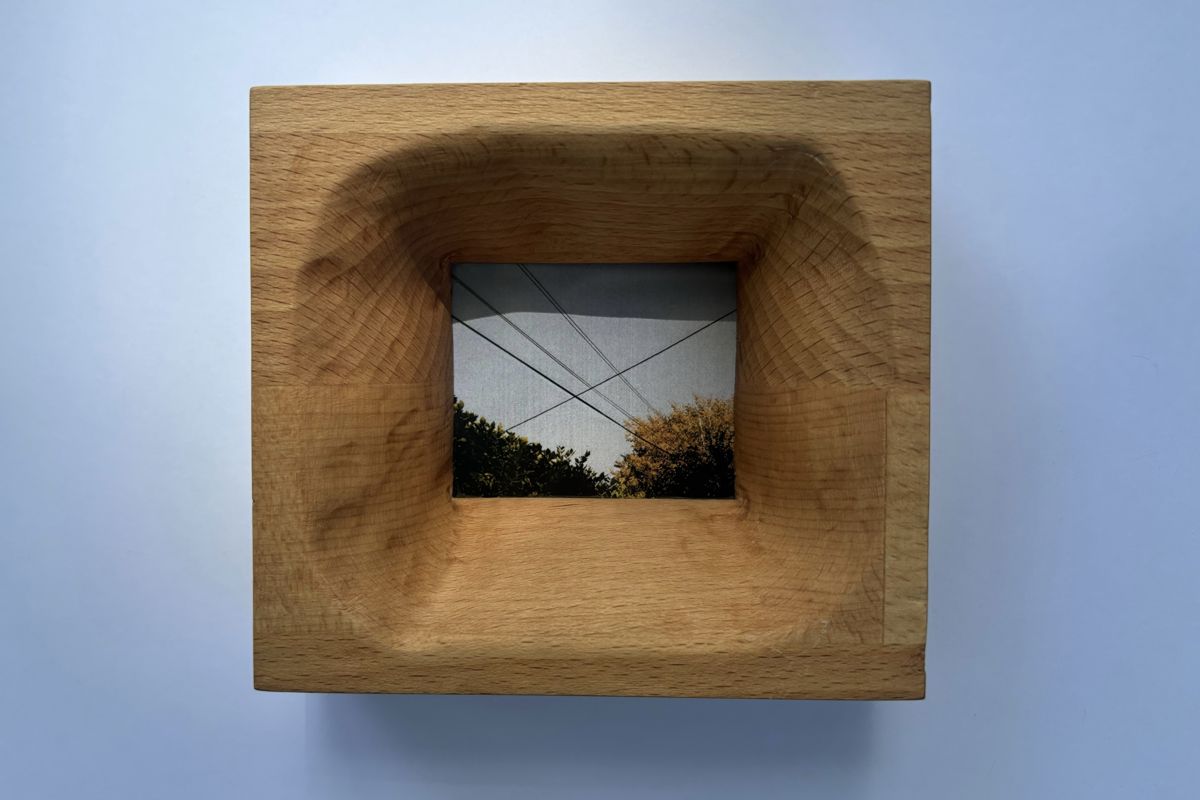 Beech block frame with a deep carved bowl, holding a photo of power lines over trees