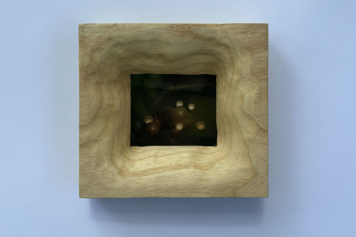 Pale ash frame with rippled carving, holding a photo of paper lanterns