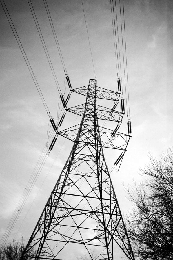Tall pylon with insulators rising above bare winter trees